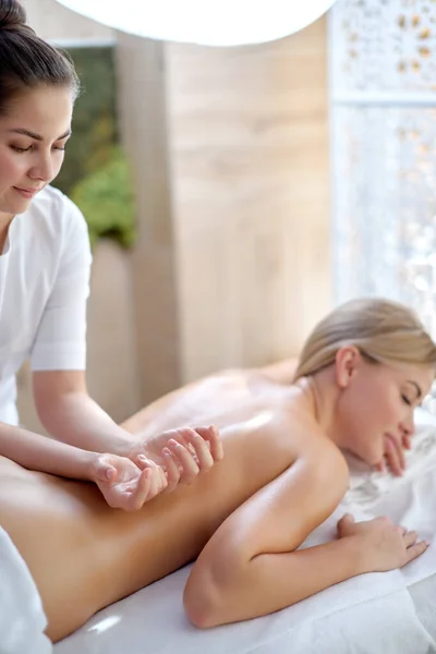 Тонка жінка, що отримує повний масаж тіла професійним масажистом у сучасному спа-центрі — стокове фото