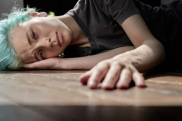 ¿Qué debo hacer? Mujer preocupada tumbada en el suelo y pensando en algo deprimente en casa. —  Fotos de Stock