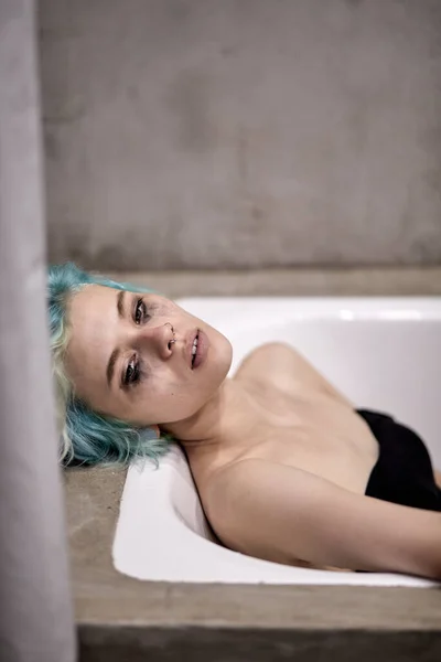 Desperat trött kvinna liggande i badkaret tittar på sidan, tänker på meningen med livet — Stockfoto