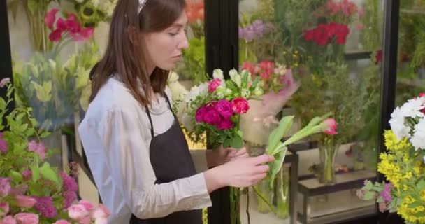 小さな仕事だ。花屋さんフラワーショップに花を配置します。花のデザインスタジオ — ストック動画