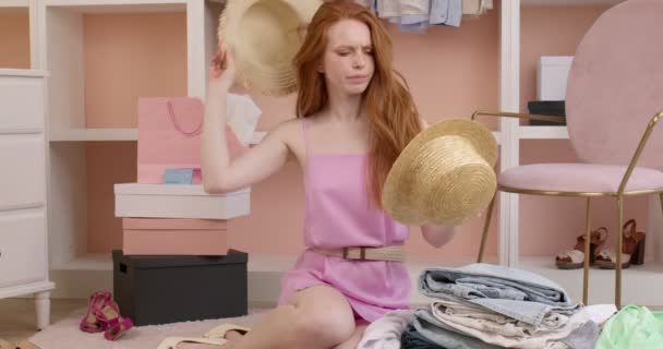 Ελκυστική γυναίκα ντυμένη με ροζ καλοκαιρινό φόρεμα δοκιμάζοντας καπέλα, επιλέγοντας το καλύτερο — Αρχείο Βίντεο