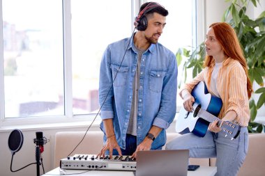 Dost canlısı beyaz erkek müzik öğretmeni kız öğrenciye talimatlar veriyor.