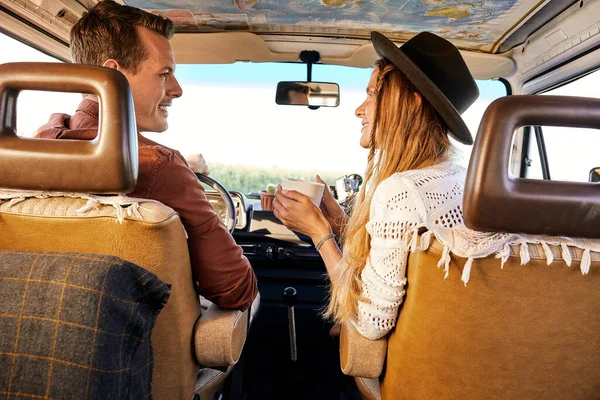 Casal alegre desfrutando de uma viagem de carro. Sorrindo homem e mulher falando enquanto dirigindo van retro — Fotografia de Stock