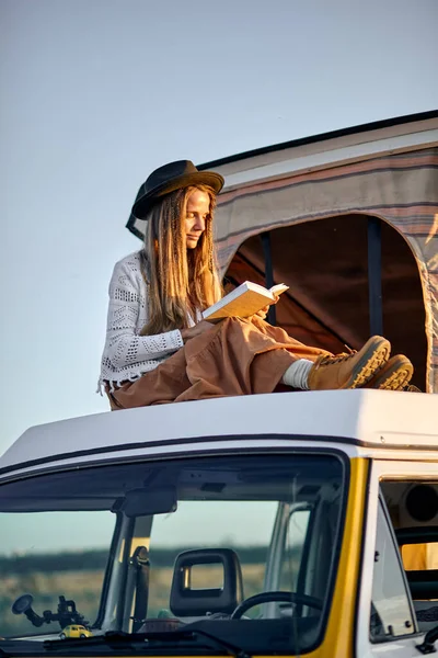 Mujer leyó un libro. caravana de vacaciones en coche. viaje de vacaciones en autocaravana. —  Fotos de Stock