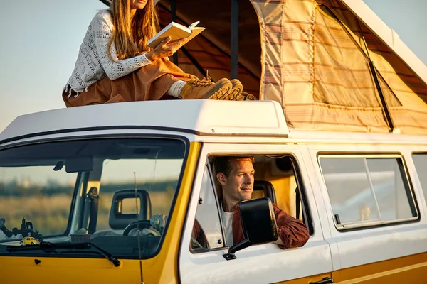 A fêmea leu um livro. Caravana de férias de carro. viagem de férias em motorhome. — Fotografia de Stock