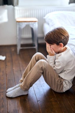 Genç çocuk yatağın yanında oturuyor, yalnız bir genci rahatsız ediyor, zorbalığa maruz bırakıyor..