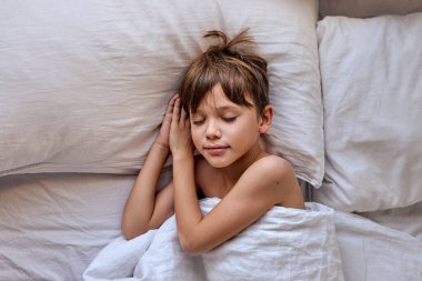 Tatlı rüyalar. Küçük tatlı çocuk çocuk, yatak yastıklarının üzerinde uyu.