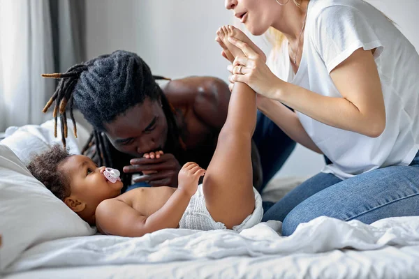 Feliz familia multiétnica, negro y caucásico padres divertirse con hija — Foto de Stock