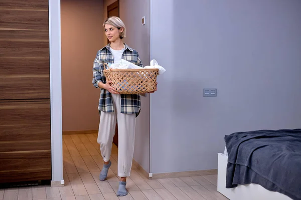 Lady doing the daily chores laundry, folded clothes in laundry basket basin — Stock Photo, Image
