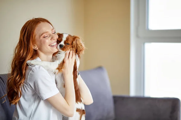 Attraktive Hündin in Freizeitkleidung Liebende Streicheleinheiten beim Spielen mit Haustier Hund zu Hause — Stockfoto