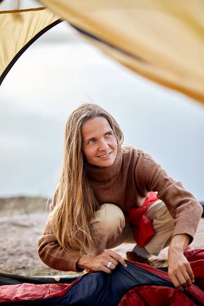 Giovane signora che prepara tenda per il campeggio, femminile fermato vicino al fiume, stile di vita attivo — Foto Stock