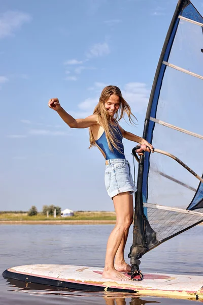 Kobieta windsurferka nad jeziorem. Piękny krajobraz. Sporty wodne letnie — Zdjęcie stockowe