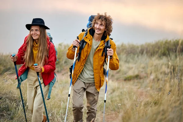 Excited couple with bag pack on back holding hiking pole during hiking jurney. — Stock Photo, Image