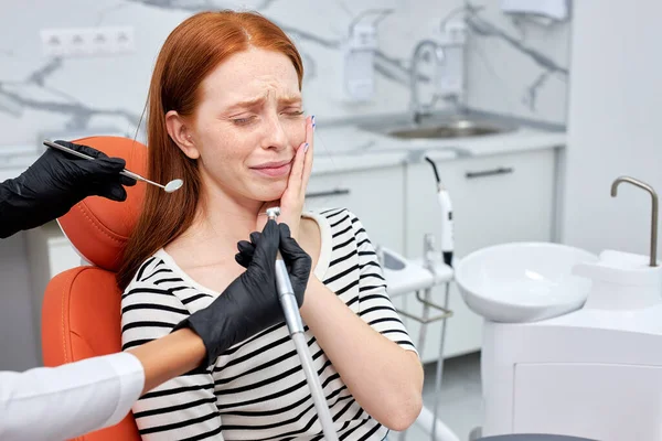 Καλλιεργημένος οδοντίατρος που εκτελεί οδοντιατρική διαδικασία πλήρωσης σε φοβισμένη γυναίκα στην οδοντιατρική κλινική. — Φωτογραφία Αρχείου