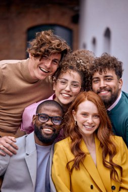 Close-up Portrait of Cheerful Multi-ethnic Business People Posing At Camera Outdoors, Cheerfully Smiling, Dressed In Fashionable Elegant Clothes. Friendly Caucasian And Afro American Colleagues