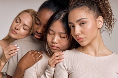 black american, caucasian, asian together isolated on studio background. sleepy women leaned on curly woman friend. diverse type on skin, lifestyle people concept. close-up portrait
