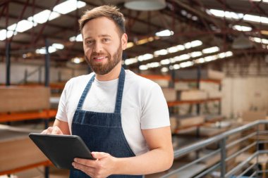 Dükkanda gülümseyen ve önlükle fotoğraf çeken işçilerin portresi