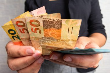 Elinde büyük miktarda para olan siyah bir kadın. Brezilya 'dan bir sürü para. Finansal, kar, kredi, maliyet, satın alma, zengin konsept.