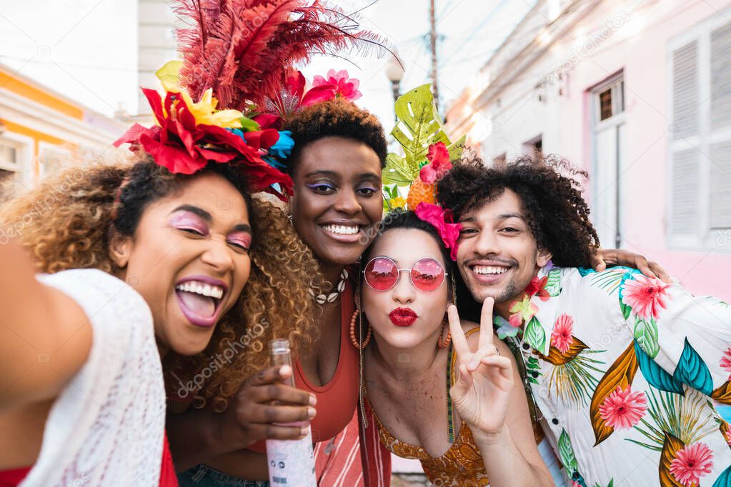 Friends in costumes have fun at carnival party in the street. Brazil holiday fun selfie with group of people together