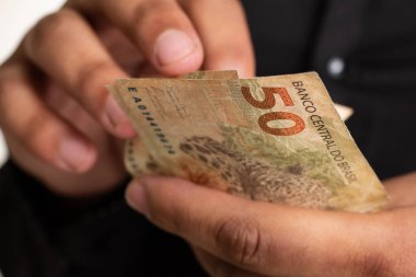 El, para banknotlarını tutuyor. Mand, Brezilya 'dan yüklü miktarda para sayıyor..