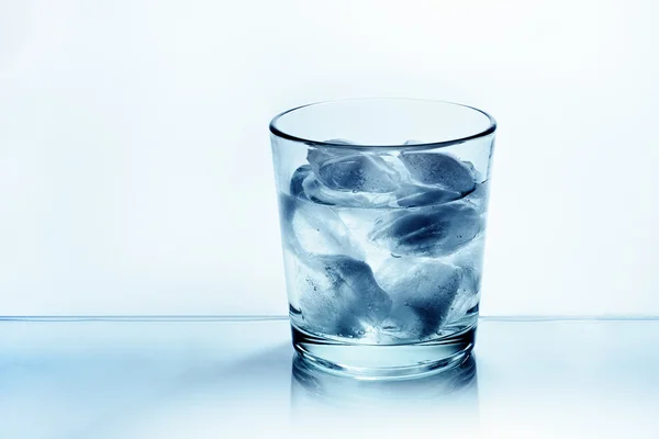 Lasillinen vettä jäällä — kuvapankkivalokuva