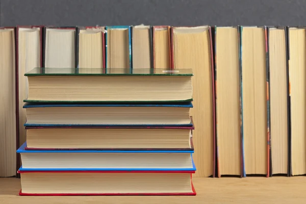 Pile de livres sur une surface en bois sur le fond d'un nu — Photo