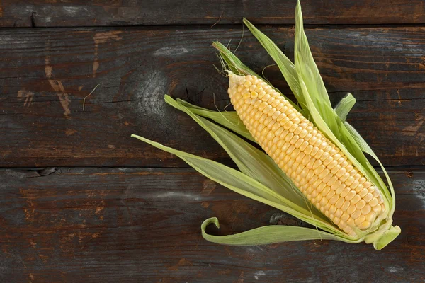 A corn cob on a wooden table — Stock Photo, Image