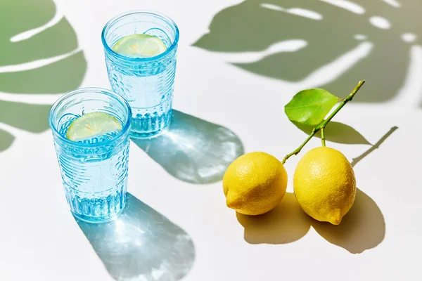 Zitronenwasser Blauen Gläsern Mit Frischen Zitronen Sonnenlicht Und Schatten Entgiften — Stockfoto