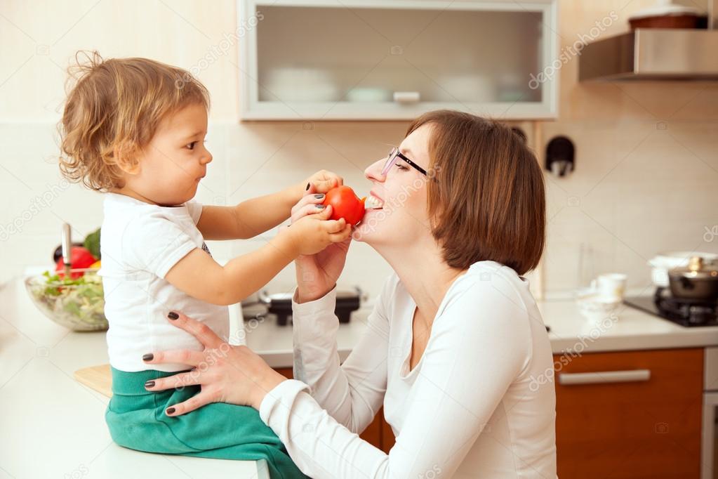 Happy mother with a baby in the kitchen