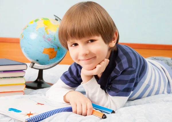 O menino com globo e caderno — Fotografia de Stock