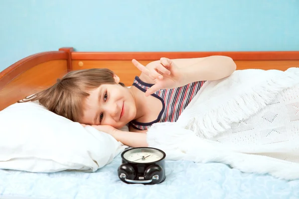 Small boy in bed with alarm clock — Stock Photo, Image