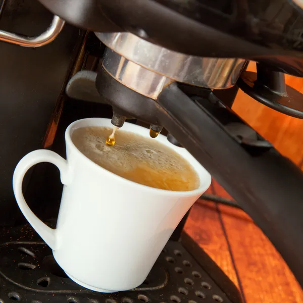 De daling van koffie druppels in Beker — Stockfoto