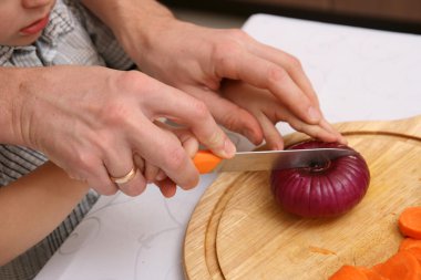 Çocuk soğan kesmek öğrenir.