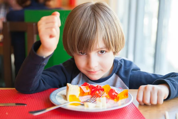 The boy eats dessert in restaurant — Stock Photo, Image