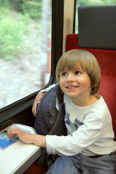 Niño pequeño se sienta cerca de la ventana en tren —  Fotos de Stock