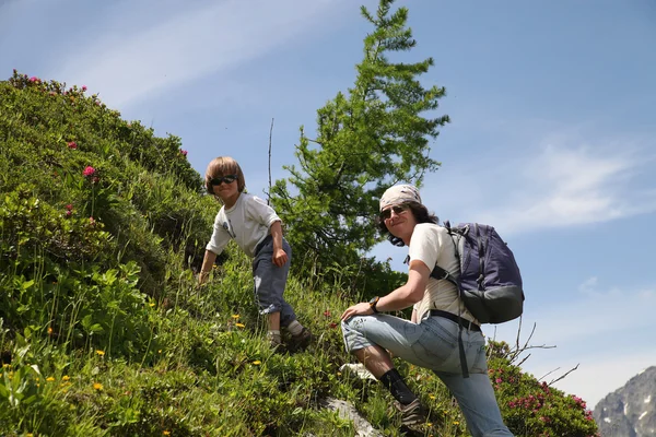 Dos personas caminan en la ladera de la montaña en verano — Foto de Stock
