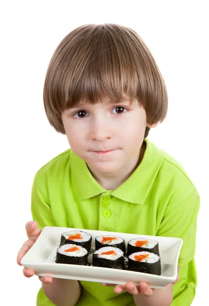 Piccolo ragazzo tiene piatto di asiatico tradizionale rotoli — Foto Stock