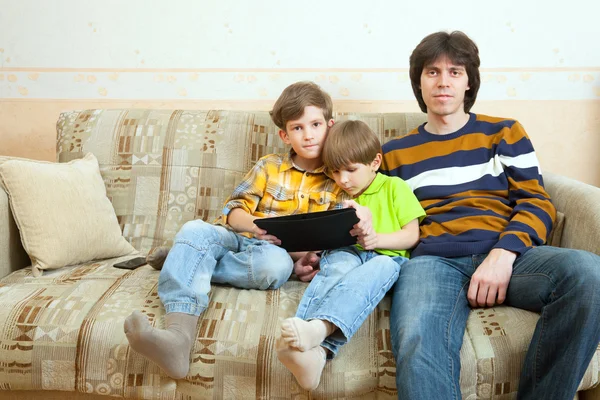 Two brothers and father sit on sofa — Stock Photo, Image