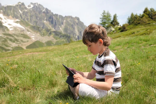 Niño con touchpad en los Alpes — Foto de Stock