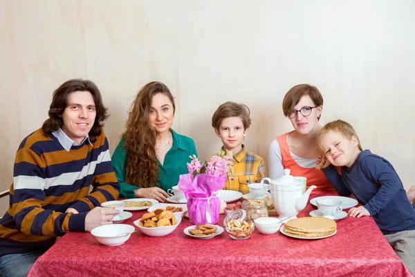 Rodina sedí u stolu karneval — Stock fotografie