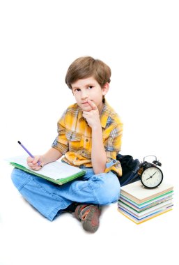 dizlerinin üstünde defter ile öğrenci