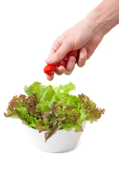 Ręka z pomidorkami i sałatka — Zdjęcie stockowe