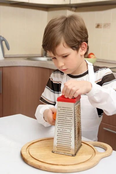 Boy with grater and carrot — Stock Photo, Image