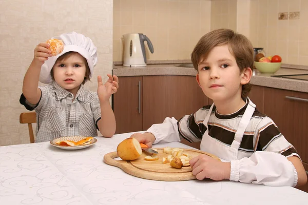 Hermanos en cocina con frutas —  Fotos de Stock