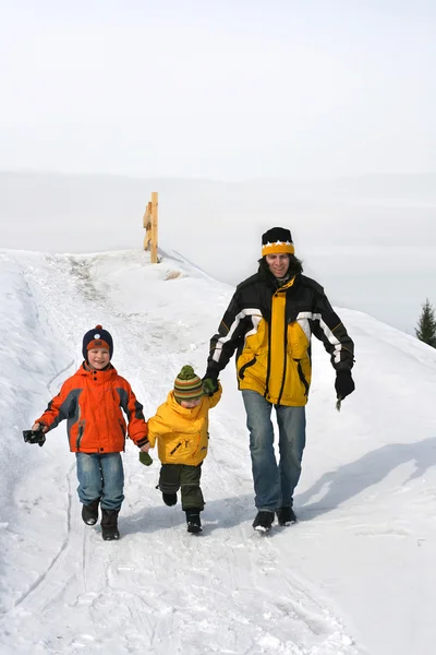 Father with childred go down the hill — Stock Photo, Image