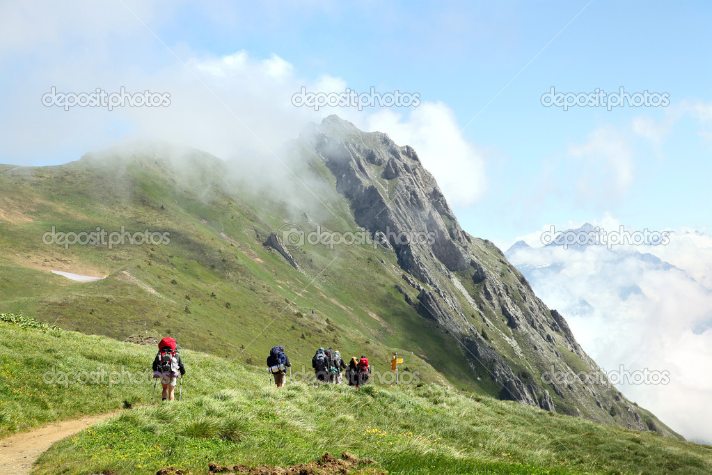 Tourist hiking on trail in mountains