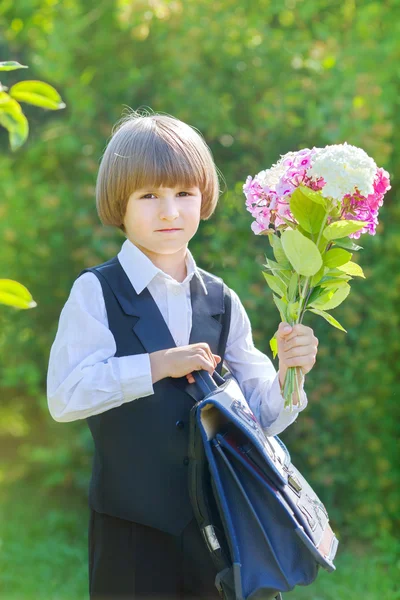 Étudiant garçon en uniforme scolaire avec un bouquet — Photo