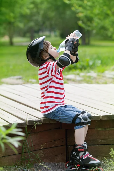 ローラー スケートで少年は、水を飲む — ストック写真