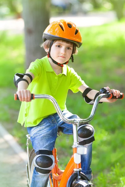 O menino dirige bicicleta no parque — Fotografia de Stock