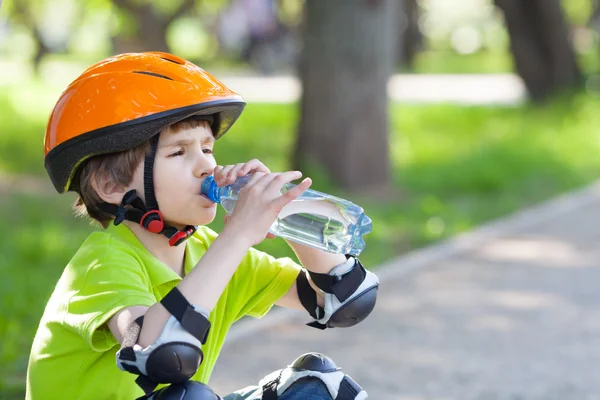 Pojke drycker vatten från flaska — Stockfoto